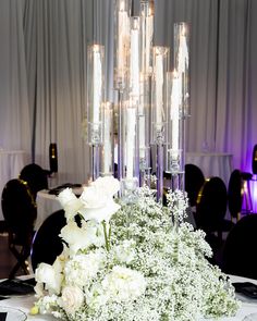 white flowers and candles are arranged on a table