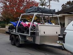 a golf cart is loaded with atvs on the back