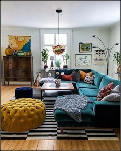 a living room filled with lots of furniture next to a wooden floor covered in rugs