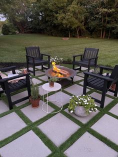 a fire pit sitting on top of a patio surrounded by lawn chairs and potted plants