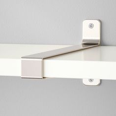 a white shelf with a metal handle on it