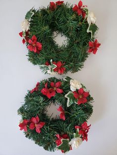 two christmas wreaths with red and white flowers