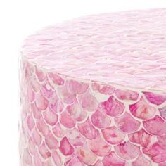 a pink and white cake covered in lots of fish scale scales on top of it