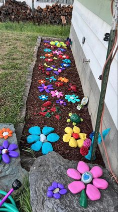 a garden with flowers and rocks in the ground next to a fence that reads, painting rock join share monze 1 d's no watering, need to fence for deer