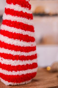 a red, white and blue knitted hat sitting on top of a wooden table