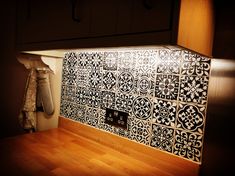 a light shines on a kitchen backsplash with black and white tile designs