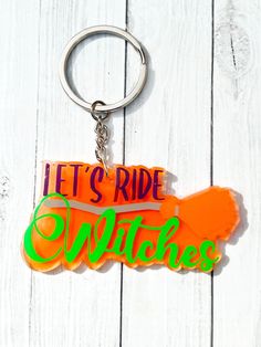 an orange and green keychain with the words let's ride witches on it