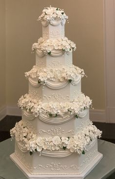 a large white wedding cake with flowers on it