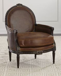 a brown leather chair sitting on top of a carpeted floor next to a white wall