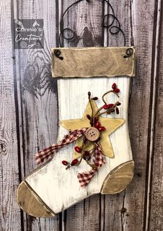 a christmas stocking hanging on the side of a wooden fence with a button and star