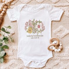 Baby Flower Bodysuit, Consider How the Wildflowers Grow, Floral Baby Christian Tee, Bible Verse Luke 12, Baby Shower Gift Looking for more inspirational apparel? Check these out: https://www.etsy.com/shop/TheGraphicPeach?ref=seller-platform-mcnav§ion_id=30193152 Our shop uses direct-to-garment printing to make our products. The design ink is sprayed on, then allowed to soak into the fibers of the garment. This process yields fine quality prints and a smooth finish on the garment. Baby clothing n Spring Baptism Cotton Onesie, Fitted White Onesie With Floral Print, Cotton Baptism Onesie With Short Sleeves, Flower Bodysuit, Luke 12, Baby Flower, Christian Tees, Flower Quotes, Gender Neutral Baby Clothes