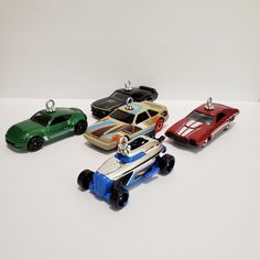 four toy cars sitting on top of a white table