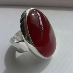 "Carnelian Silver Ring This is a classic ring with a beautiful red Carnelian 30 x 22 mm, settled on Sterling Silver band width 8 mm. Carnelian, in shades of red combines the energy of the pure red ray, and the exuberance and joy of the orange. It is the color of strength and vitality, both physical and spiritual. This ring match with the pendant that you can see in the following link: http://etsy.me/1WOrkQM If you want order the ring and the pendant, ask me for an additional 10 % OFF. *This jewe Classic Red Ruby Ring, Oval Cabochon, Classic Red Ruby Ring With Oval Cabochon, Red Oval Cabochon Ring, Polished Carnelian Oval Rings, Red Carnelian Ring With Polished Finish, Red Carnelian Rings With Polished Finish, Red Polished Carnelian Rings, Formal Red Carnelian Ring, Red Carnelian Cabochon Ruby Ring