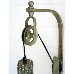 an old fashioned wall light hanging on the side of a house with a lamp attached to it