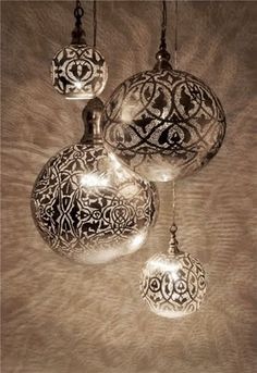 three glass ornaments hanging from a ceiling in the shape of an ornament with intricate designs