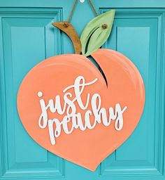 an orange heart shaped door hanger with the words just peachy painted on it