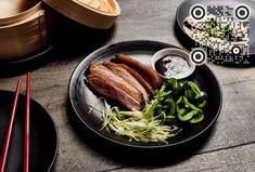 black plates with food and chopsticks on a wooden table