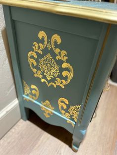 a green and gold painted cabinet in a room