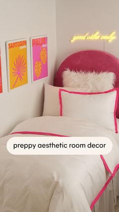 a bed with white sheets and pink headboard in a room that has posters on the wall