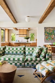 a green and white checkered couch in a living room next to a table with chairs