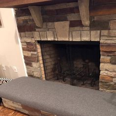 a stone fireplace with a bench in front of it