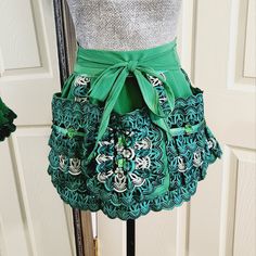 there is a skirt made out of crochet and green ribbon on the mannequin