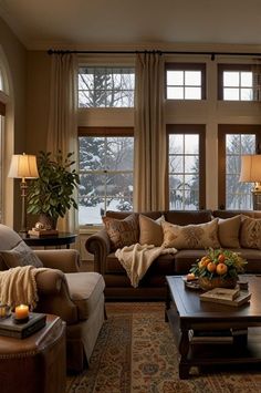 a living room filled with lots of furniture next to two large windows covered in blankets