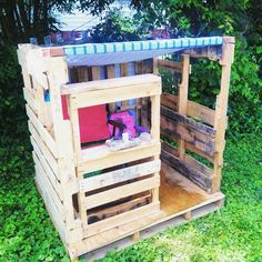 a wooden structure made out of pallets in the grass