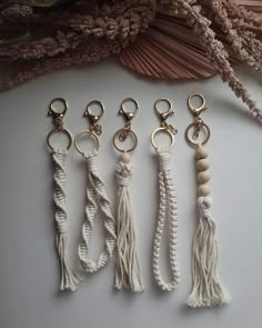 four keychains with tassels and beads hanging from them on a table