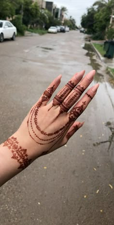 a woman's hand with hendix on it and cars parked in the background