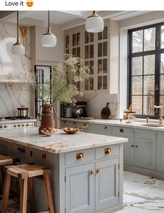 a large kitchen with marble counter tops and wooden stools in front of the island