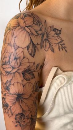 a woman's arm with flowers on it, and the back of her shoulder