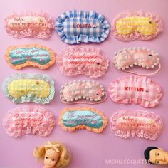 many different types of hair clips on a pink surface with barbie dolls next to them