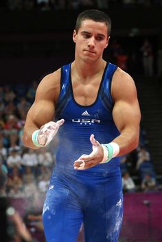 a man standing on top of a wrestling ring holding his hands out to the side