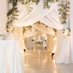 an aisle decorated with white flowers and greenery