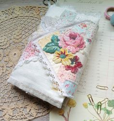 some fabric and scissors are laying next to each other on a doily covered table