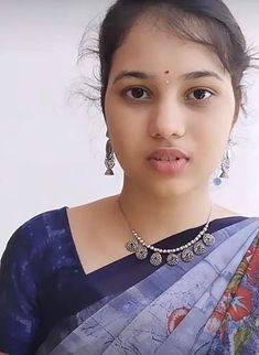 a woman in a blue sari is looking at the camera with an expression on her face