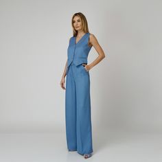 Introducing our Skye Silk Crepe Pants, a statement of luxurious comfort and timeless style. Tailored from  blue silk crepe with a wide-leg cut, they feature expertly placed darts that contour the waist and flatter the silhouette. The pressed crease detail offers a touch of refinement, elevating the overall look with understated polish. A concealed zipper and hook fastening in the front ensures a seamless finish, while the inclusion of pockets adds a practical yet chic element to the ensemble.  M Tailored Blue Wide Leg Pants For Formal Occasions, Tailored Wide Leg Blue Pants For Formal Occasions, Elegant Wide Leg Silk Pantsuit, Modern Blue Wide-leg Pants, Modern Wide Leg Pants For Summer Formal Events, Modern Wide Leg Pants For Summer Formal Occasions, Modern Formal Wide Leg Pants For Summer, Elegant Blue Straight Leg Pantsuit, Elegant Blue Wide Leg Pants For Work