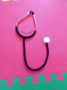 a stethoscope laying on top of a pink mat