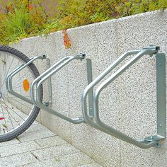 there is a bike locked to the side of a wall next to a bicycle rack