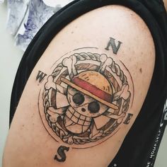 a man with a pirate skull and crossbones tattoo on his upper half arm