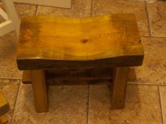 a wooden bench sitting on top of a tiled floor