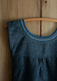 a blue dress hanging on a wooden hanger