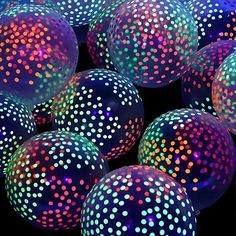 many colorful balls with dots on them in the dark