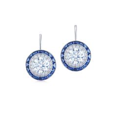 These drop earrings feature round brilliant diamonds bordered by double frames of diamonds and calibré cut sapphires. Diamond Earring Jackets, Silhouette Earring, Halo Diamond Earrings, Diamond Earrings Studs Round, Earrings Minimal, Buying An Engagement Ring, Earring Jackets, Diamond Earring, Diamond Drop Earrings