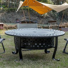 an outdoor table and chairs in the grass