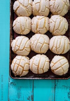 a pan filled with white frosted cookies on top of a blue table