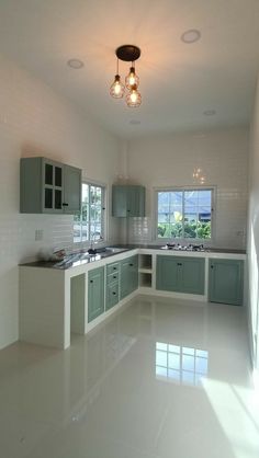 an empty kitchen with white floors and green cabinets