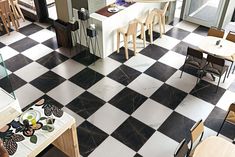 a black and white checkered floor in a restaurant with tables, chairs, and counter tops