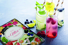 three glass bottles filled with liquid and berries